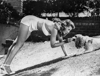 Rita Hayworth Feeding a Dog