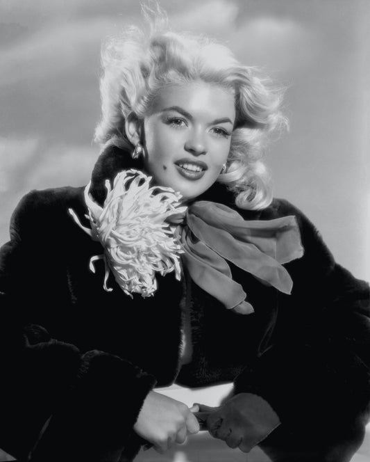 Jayne Mansfield pose souriante avec un manteau